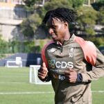 David Ankeye corre in allenamento con la maglia del Genoa numero 30, sul campo con lo sponsor CDS ben visibile.