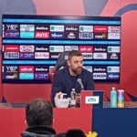 De Rossi parla in conferenza stampa dopo Genoa-Bologna, con il richiamo a “Vivo per queste emozioni” sullo sfondo.