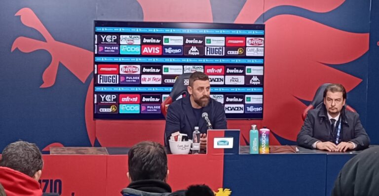 De Rossi parla in conferenza stampa dopo Genoa-Bologna, con il richiamo a “Vivo per queste emozioni” sullo sfondo.