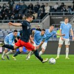 Ruslan Malinovskyi calcia il rigore del Genoa all’Olimpico di Roma mentre i giocatori della Lazio osservano, con il pallone pronto sul dischetto.