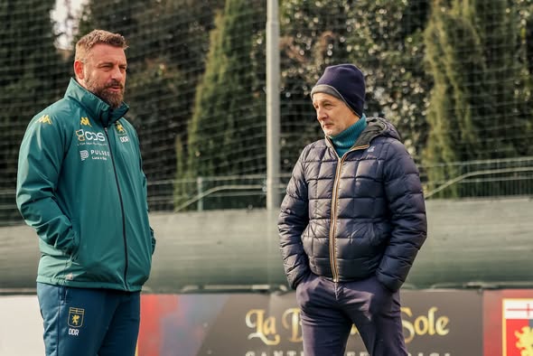 Durante l’allenamento del Genoa in vista di Cremona, Daniele De Rossi parla con Mario Bortolazzi a bordocampo, tra esercizi e preparazione.