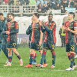 Nel post su Open Var, i giocatori del Genoa applaudono sotto la pioggia mentre il Napoli resta sullo sfondo dopo un episodio contestato.