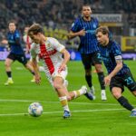 Al Meazza, un giocatore del Genoa in maglia bianca e rossa sfida un difensore dell’Inter in nerazzurro durante la gara di De Rossi finita 2-0.