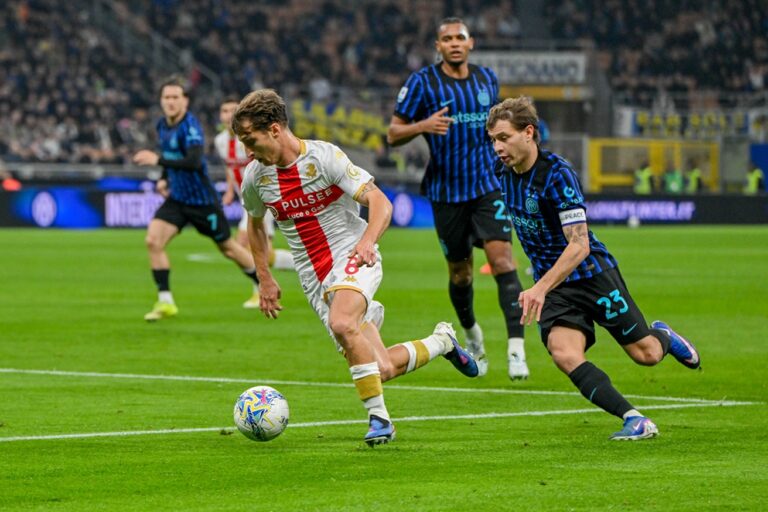 Al Meazza, un giocatore del Genoa in maglia bianca e rossa sfida un difensore dell’Inter in nerazzurro durante la gara di De Rossi finita 2-0.