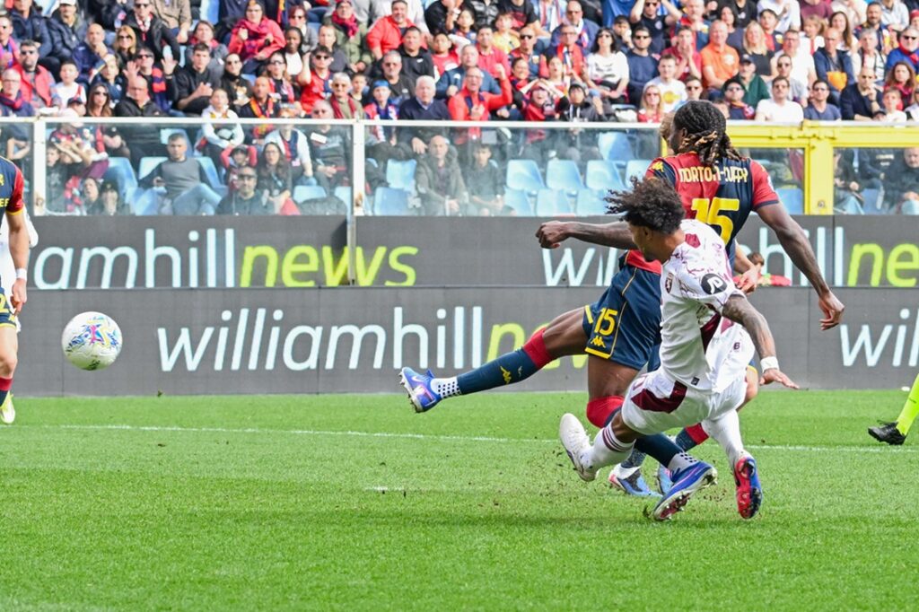Nel Genoa – Torino di Campionato 2025/2026, Norton-Cuffy anticipa un avversario granata mentre il pallone scorre nell'area davanti alla curva gremita.