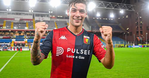 Dopo la vittoria del Paok a Salonicco, Alessandro Vogliacco sorride in maglia Genoa con i pugni alzati sotto le luci dello stadio.