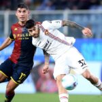 Nel confronto Cremonese-Genoa di Serie A, un giocatore rossoblù pressa un avversario grigiorosso durante lo scontro salvezza allo Zini.