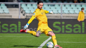 Bijlow, portiere del Genoa in maglia giallo brillante, in azione su campo verde con pallone, tatoos visibili sulle gambe, concentrato e right pronta a intervenire