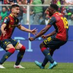 Ekuban in azione nel match Genoa-Sassuolo, divisa rosso-neroverde con dettagli gialli e numero 19, esultanza in area tra contrasto e balzi
