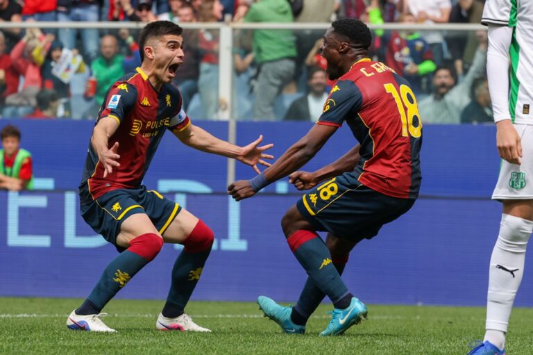Ekuban in azione nel match Genoa-Sassuolo, divisa rosso-neroverde con dettagli gialli e numero 19, esultanza in area tra contrasto e balzi