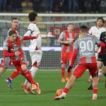 Cremonese contro Cagliari: giocatori in maglie rosse e pantaloncini grigi si contendono il pallone davanti alla porta, con un overall dinamico e intenso della partita tra Cremonese e Cagliari, presenza di Pinamonti in campo