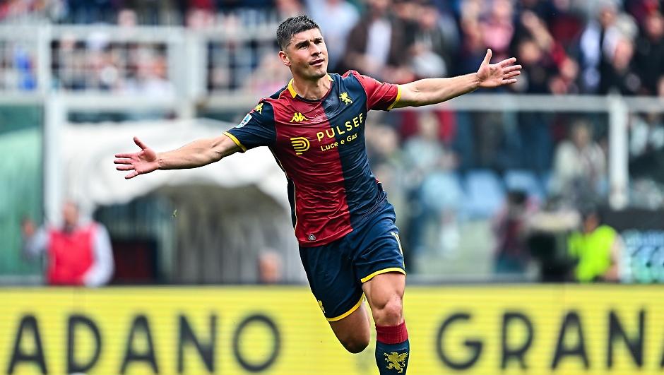 Malinovskyi del Genoa in maglia rossa-blu, braccia aperte in gesto di esultanza durante Genoa Sassuolo 2-1, pubblico sullo sfondo.