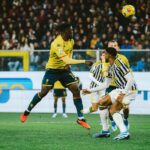 Bremer e McKennie a centrocampo in azione, Juventus in giallo contro Genoa, Baldanzi entra nel secondo tempo; scena dinamica con pallone in aria e pubblico sullo sfondo