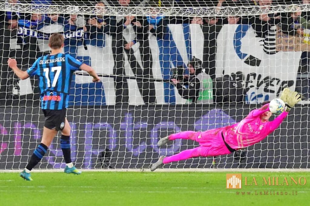 Edoardo Motta in tuffo in maglia pink respinge sotto la traversa, mentre de Ketelaere, con la maglia blu dell’Inter, guarda il pallone.