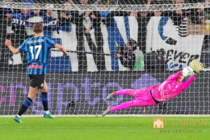 Edoardo Motta in tuffo in maglia pink respinge sotto la traversa, mentre de Ketelaere, con la maglia blu dell’Inter, guarda il pallone.