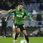 Giocatore del Sassuolo in maglia verde con palla in gioco, contrastato da un avversario del Genoa durante Genoa-Sassuolo