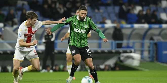 Giocatore del Sassuolo in maglia verde con palla in gioco, contrastato da un avversario del Genoa durante Genoa-Sassuolo