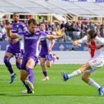 Contrasto in Fiorentina–Genoa: giocatori in maglia viola e bianca, palla sull’erba al Franchi, pagelle dopo una gara avara di occasioni e Massimi.