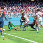 Contrasto in area tra Genoa e Milan: Vasquez in maglia rossoblù in azione sul campo verde, partita 1-2 al Luigi Ferraris.