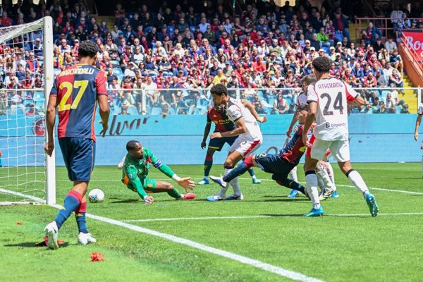 Contrasto in area tra Genoa e Milan: Vasquez in maglia rossoblù in azione sul campo verde, partita 1-2 al Luigi Ferraris.