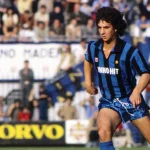 Evaristo Beccalossi in maglia dell’Inter neroazzurra a righe, capelli scuri, mentre corre in uno stadio gremito di pubblico